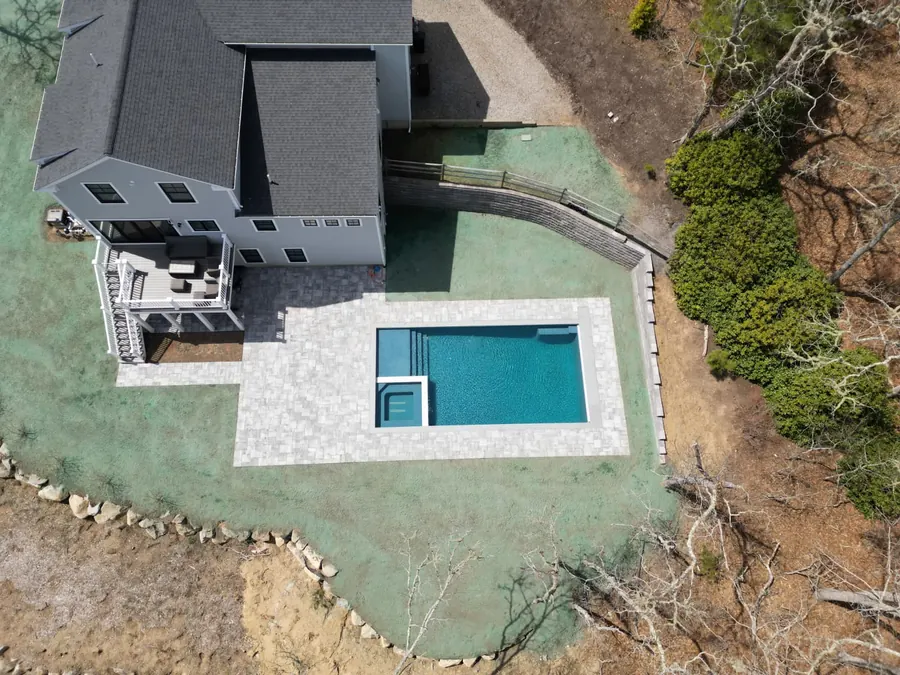Aerial view of a hillside pool with an attached spa