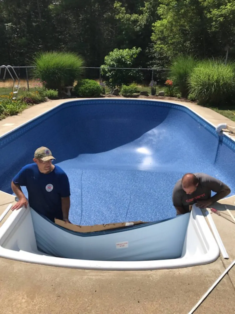 Crew fitting a new vinyl liner