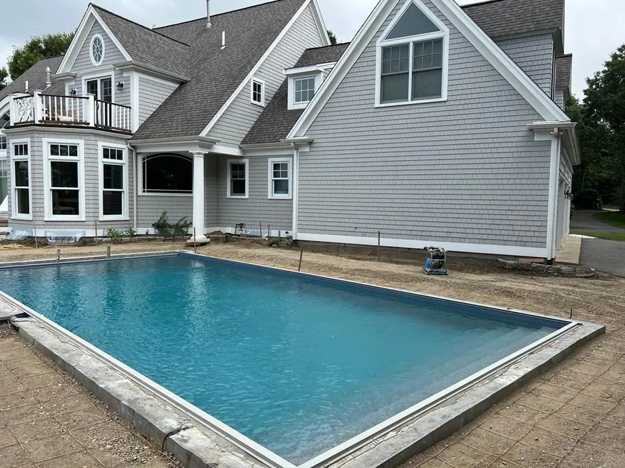 New pool behind a grey Cape house