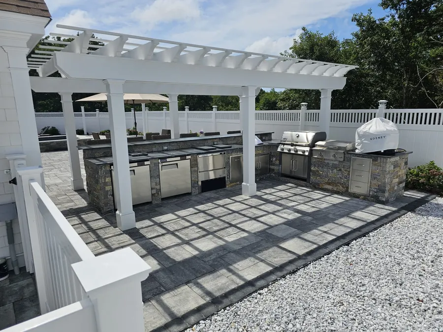 Pool deck with a pergola and outdoor kitchen